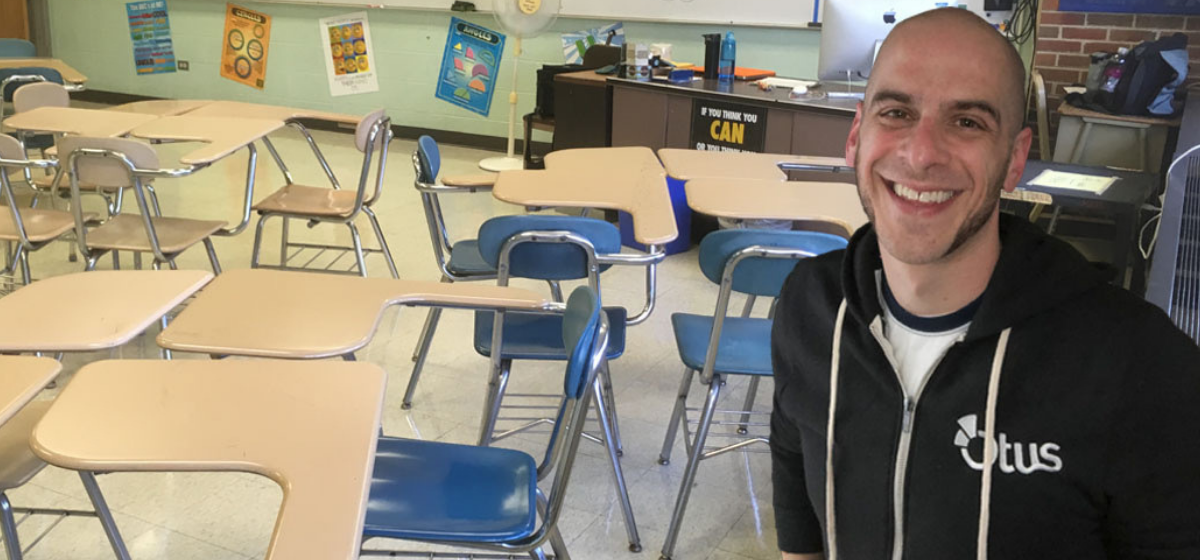 Matt wearing an Otus zip-up sweater in a classroom.
